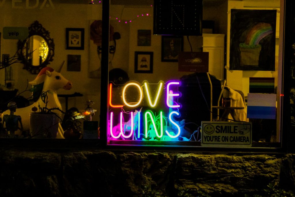 "Love Wins" Neon Sign In A Storefront At Night